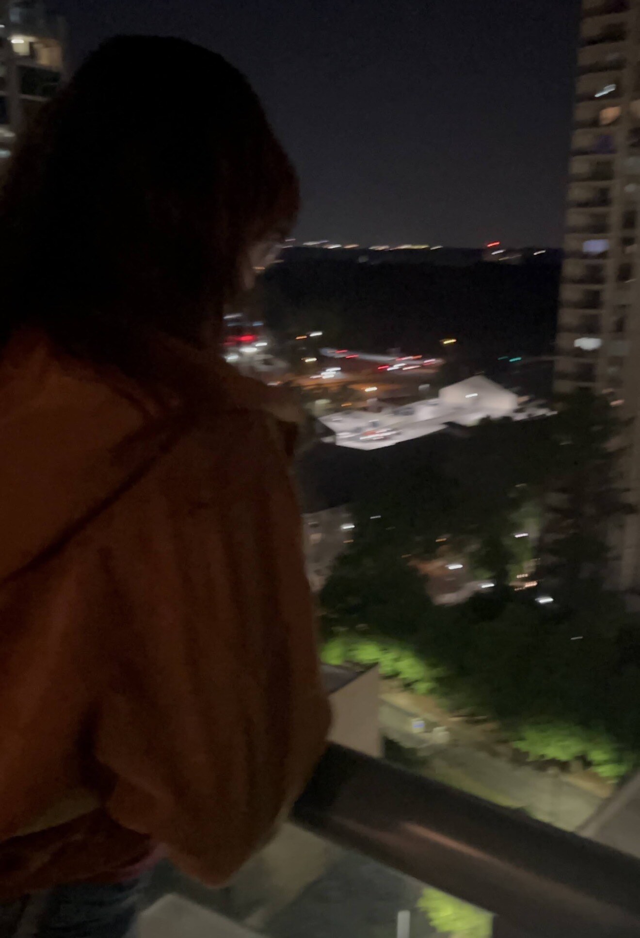 LJ overlooking Atlanta from a high-rise balcony at night